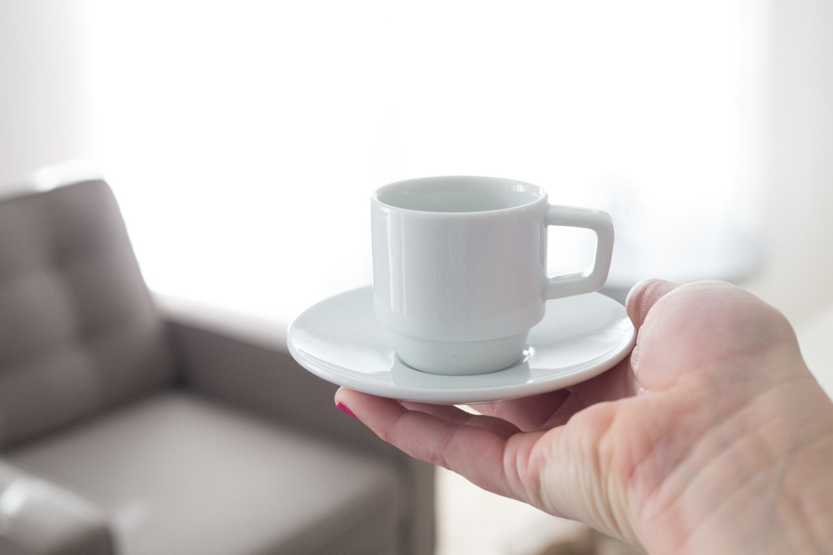 手に載せたコーヒーカップとソーサー