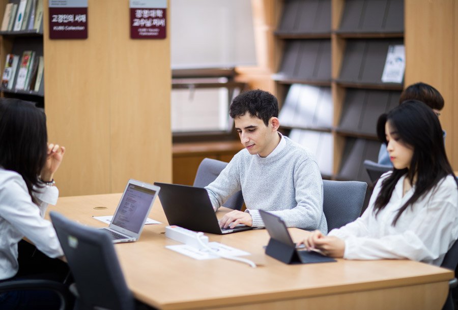 机を囲んで勉強する学生たち