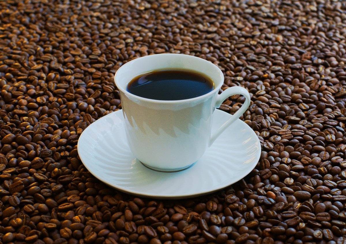 コーヒー豆に囲まれた一杯のコーヒー